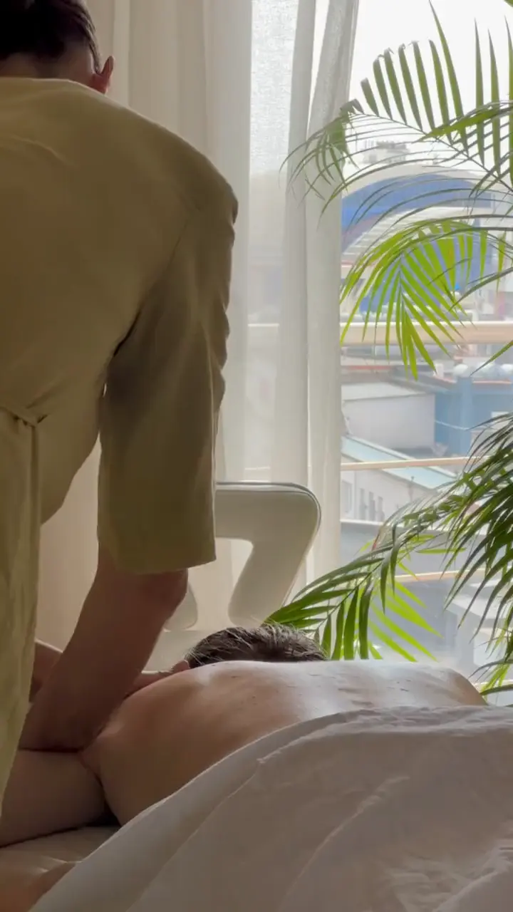 Therapist working on a client's back by the window at Sundara Studio