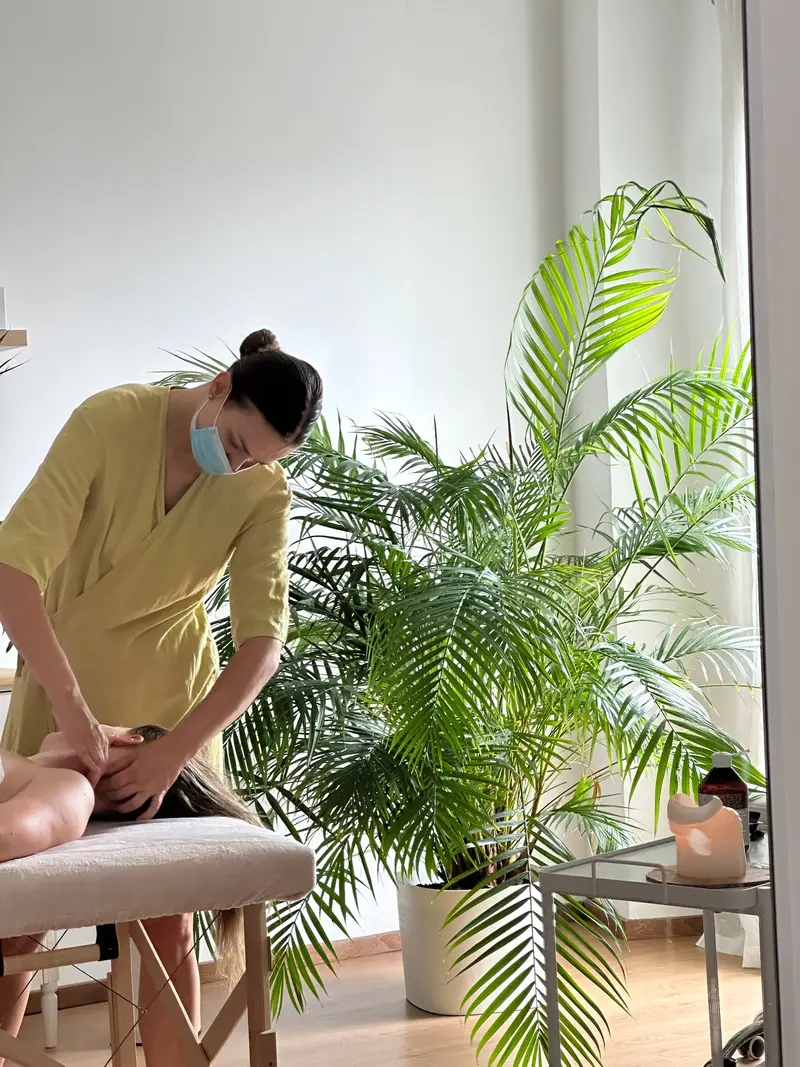 Neck and shoulder massage next to a large palm at Sundara Studio