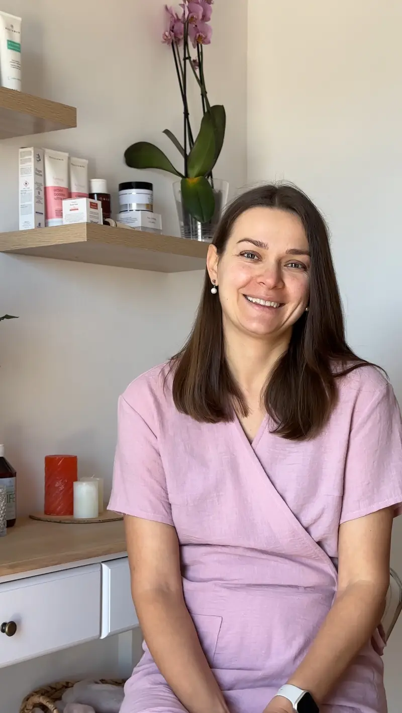 Oksana, founder of Sundara Studio, smiling in her treatment room